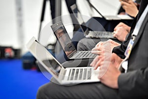 Journalists hands typing on laptops during a press conference