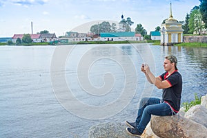 Journey. A teenager admires the beautiful landscape. The Nile Desert. Nilo - Stolobenskaya Pustyn Monastery. Tver region. Russia.