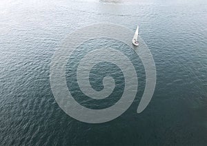 Top view of a white boat sailing in the ocean