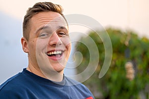 Jovial attractive young man laughing at the camera photo