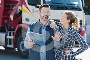jovial man and woman in front transport lorry photo