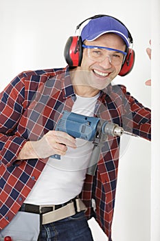 jovial mature man using drill