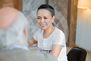 Jovial volunteer sitting with senior man