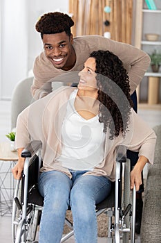 jovial young couple in home woman in wheelchair