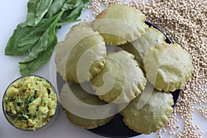 Jowar palak puri or sorghum spinach fried flat bread. Fried bread made of sorghum millet flour and pureed spinach. Served with