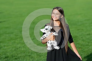 The joy of best things. Happy child hold toy dog on green grass. Pet animal. Friends and friendship. Playing games