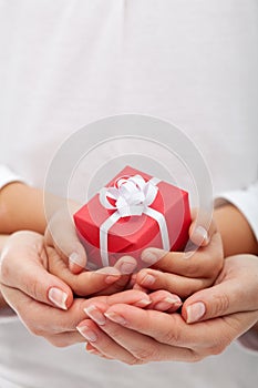 The joy of giving - small gift box in woman and child hands