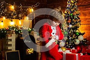 Joy and happiness. Childhood moments. Kid boy santa hold christmas gift. Christmas stocking concept. Child cheerful face