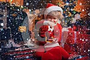 Joy and happiness. Childhood moments. Kid boy santa hold christmas gift red sock. Christmas stocking concept. Child