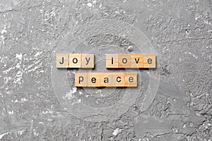Joy love peace word written on wood block. joy love peace text on cement table for your desing, concept