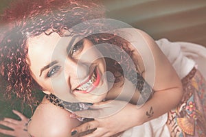 Joy of smiling young woman with curly red hair