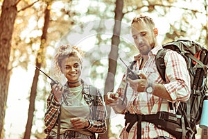 Joyful active couple speaking on walkie talkies photo