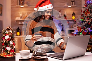 Joyful adult doing online shopping for christmas