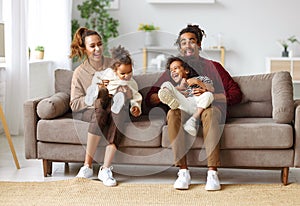 Joyful african american family parents and two little kids having fun together at home