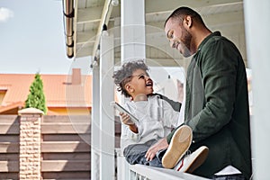 joyful african american father and son