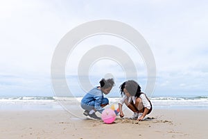Joyful African American kid enjoying with sand together at beach