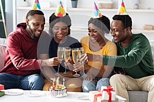 Joyful african american men and women celebrating birthday at home