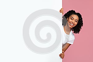 Joyful African American Woman Looking Out Behind Blank Advertisement Board