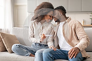 Joyful African Husband And Wife Celebrating Positive Pregnancy Test Indoor