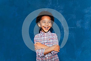 Joyful african kid boy laughing at humor joke on blue background