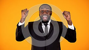 Joyful african male in formalwear making yes gesture, successful startup, winner