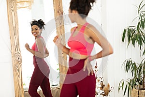 Joyful African Woman After Weight-Loss Looking In Mirror Standing Indoors