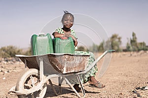 Joyful African Young Woman Transporting Natural Water for lack of water symbol