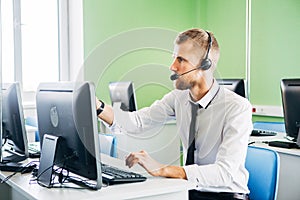 Joyful agent working in a call center with his headset