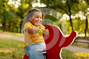 Joyful Asian Baby Girl Riding Coil Spring At Outdoor Playground