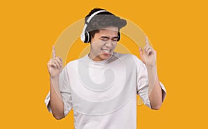 Joyful asian guy enjoying music with headphones