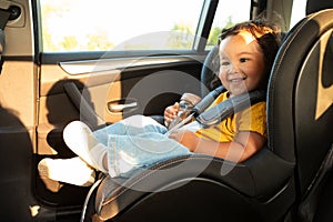 Joyful Asian Toddler Girl Sitting in Baby Seat In Vehicle