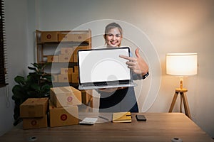 Joyful asian woman, showing her laptop with empty white mockup screen, rejoices in success, looks at camera, make YES