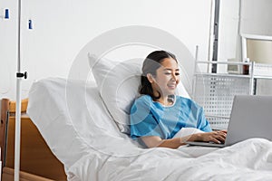 joyful asian woman typing on laptop