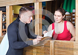 Joyful athletic man talking to girl at reception