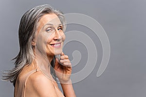 Joyful attractive senior woman smiling and looks at the camera