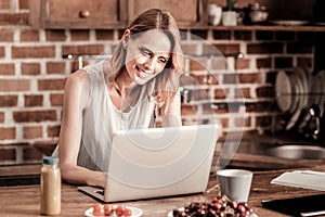 Joyful attractive woman using a laptop