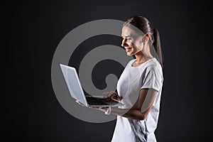 Joyful attractive woman using a laptop