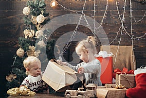 Joyful baby looking at camera in christmas at home. Cheerful cute child opening a Christmas present. Cute little child