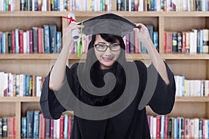 Joyful bachelor celebrate graduation in library