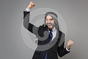 Joyful bearded arabian muslim businessman in keffiyeh kafiya ring igal agal classic black suit tie isolated on gray