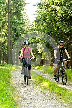Joyful biker couple in woods