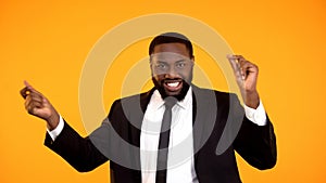 Joyful black businessman making dancing movements successful deal rich and sexy