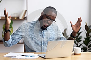 Joyful black businessman talking with friend make video call