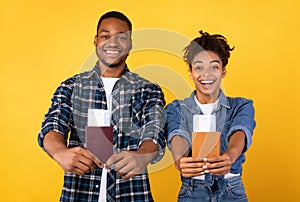 Joyful Black Couple Showing Travel Tickets Posing Over Yellow Background