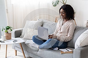Joyful Black Freelancer Woman Working With Laptop Computer At Home