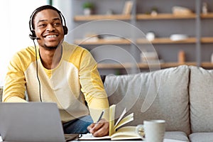 Joyful black guy having online class at home