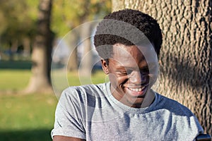 Joyful Black guy spending time outdoors in city park