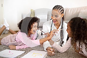 Joyful Black Mommy And Daughters Drawing And Fooling Indoors