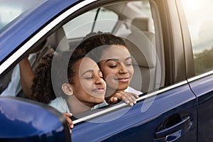 Joyful Black Mother And Daughter Sitting In Automobile Enjoying Trip