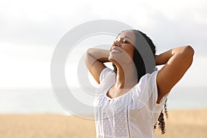 Joyful black woman breathing on the beach